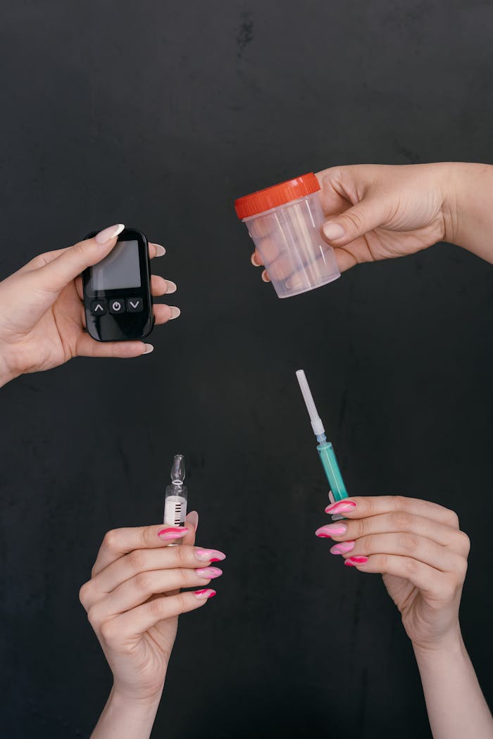 Hands displaying diabetes management tools including a glucometer, insulin syringe, and container.